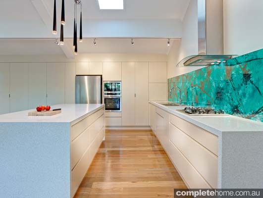 We love the acrylic couture malachite green splashbacks, which add intense colour and drama to the open kitchen.