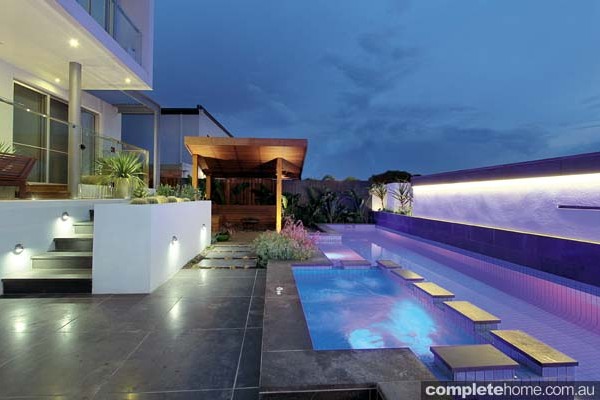 A stunning modern pool from Baden Pools illuminated at night.