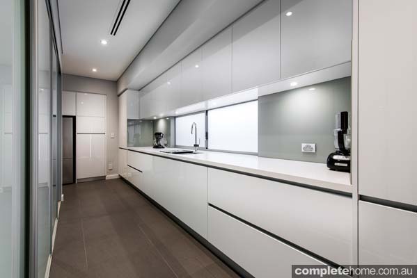 A contemporary kitchen with pure white stone benchtops.