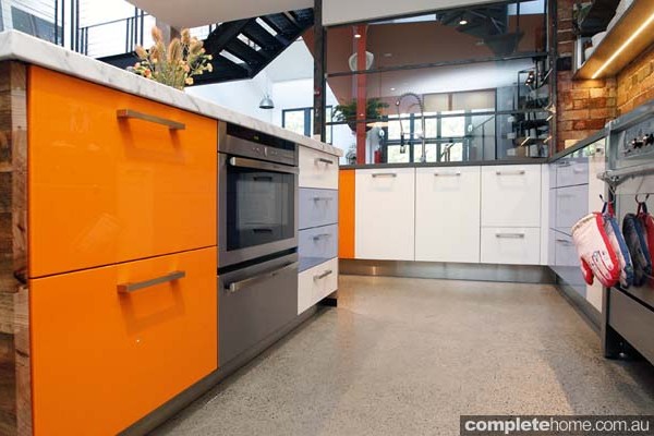 These orange draws make a bold statement on these kitchen cabinets.