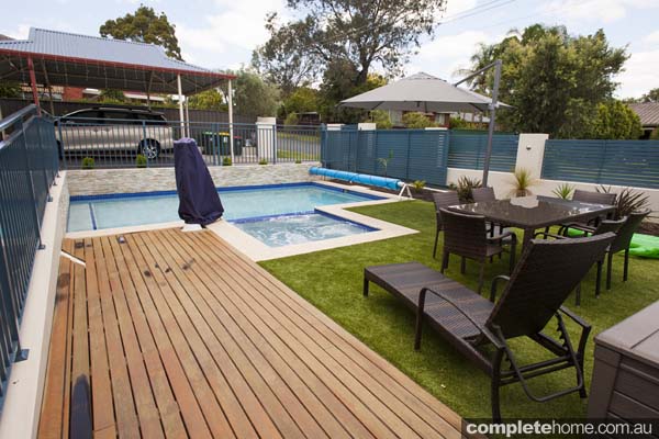 jade swimming pool design with sandstone paving and decking