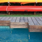Pool corner with wooden platform and a red kayak