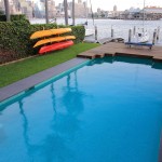 Simple pool with kayaks and a view of the city