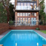 Simple pool next to a building surrounded by trees