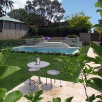 A modern pool newt to a lawn and outdoor furniture