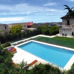 A modern pool next to buildings and a view of the city