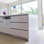 A white sleek kitchen with big windows