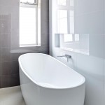 The dark, large-format tiles, with white gloss tiles for the side walls, creates a sense of grandeur