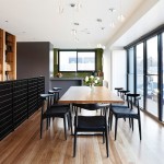 Dark-coloured chairs create contrast against warm timber