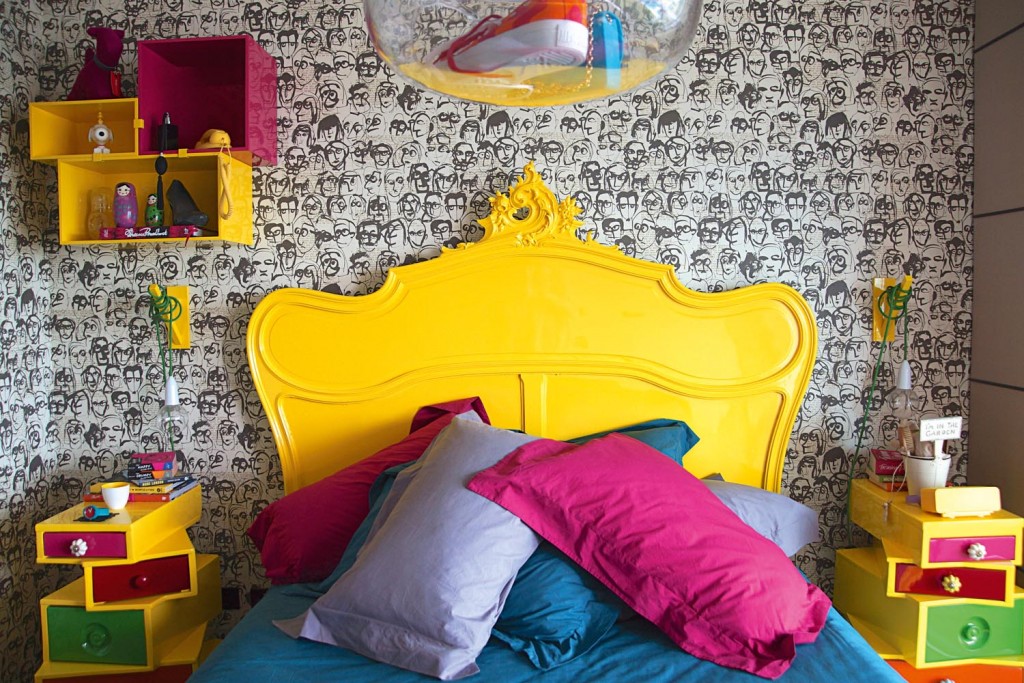 This room is all about the energy, clashing bright colours against the monochromatic wallpaper