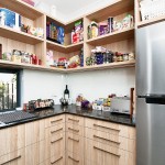 A simple kitchen with open pantry and a silver fridge