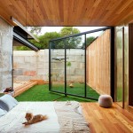 The bedroom features a large glass door that ensures the small space is filled with light