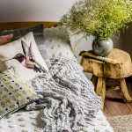 Haze quilt cover and standard pillowcases in white, Kew cushion in blush, Kimberly cushion, Equinox pastel cushion and Marmaris cushion. linenhouse.com.au Grey ceramic vase. orsonandblake.com.au Wooden table, large calligraphy brush in pale blue and Chantico rug. stonepony.com.au Dorsal Italy Ergo Posture slat bed base in beech and Bellagio timber headboard in beech. Stella Rubino Euro latex mattress. thecomfortshop.com.au