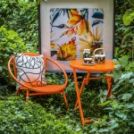 Bliss wicker chair and ergo table in orange. tofs.com.au Luscious giclée print framed in black from the Jamie  Durie x The Canvas Workshop collaboration. 100cm x 100cm. thecanvasworkshop.com.au Bottna cushion, Oiva/Unikko jug, teapot, teacup and plate. marimekko.com